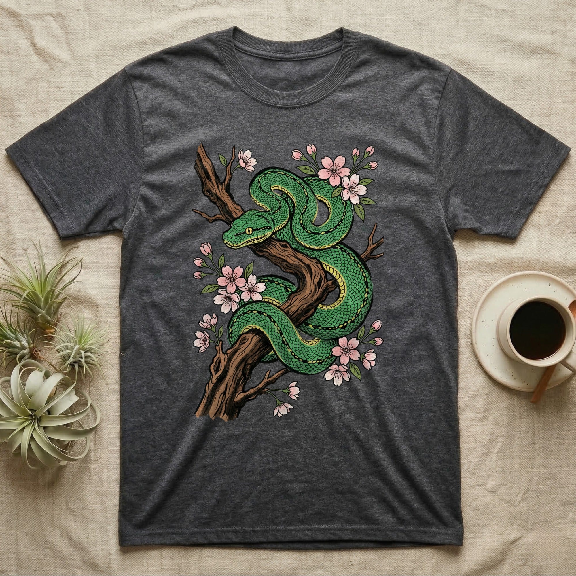 Green snake coiled on a branch with pink cherry blossoms.
