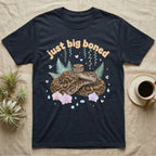 Burmese Python Baby T-Shirt in Navy — Massive coiled Burmese python among pastel ferns and orchids under puffy butterscotch bubble text "just big boned".