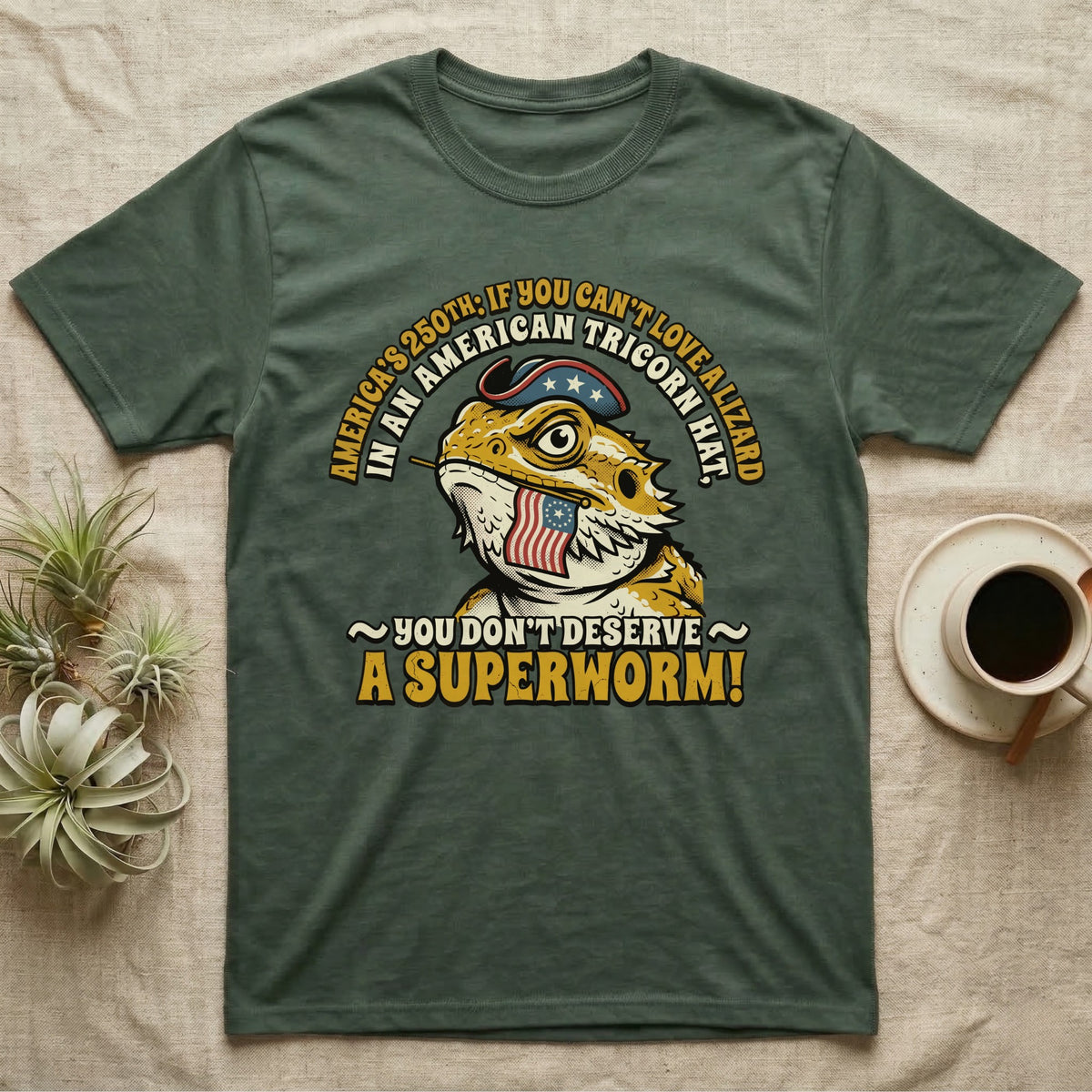Bearded Dragon Tricorn Tee in Military Green — Bold woodcut tee of a bearded dragon in a colonial tricorn hat, gold and cream text reading You Don't Deserve A Superworm, on black.