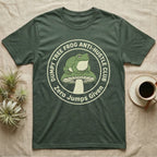 Green t-shirt with a frog on a mushroom, "Dumpy Tree Frog Anti-Hustle Club" text.