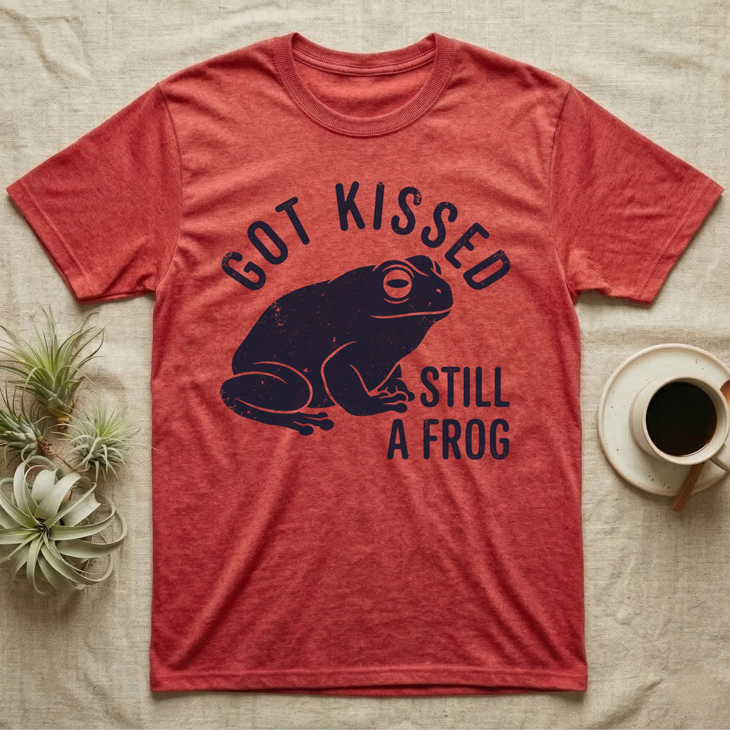 Tree Frog Kissed T-Shirt in Heather Red — Worn navy silhouette of a dumpy White's tree frog under the words Got Kissed Still A Frog