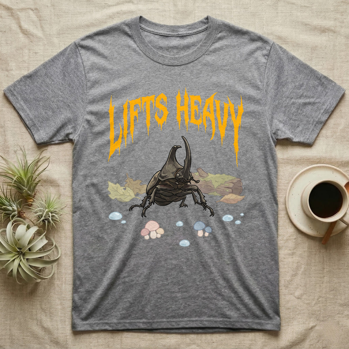 Rhino Beetle Feral T-Shirt in Sport Grey — Horned rhinoceros beetle standing head-on below a dripping amber-gold metal "Lifts Heavy" wordmark