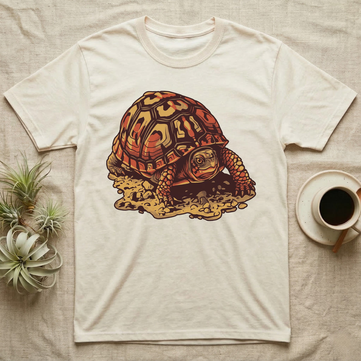 Vintage ink illustration of an Eastern box turtle crawling across sandy pebbles, high-domed shell shown in rust-red and amber, no on-shirt text. — shown on a Natural tee.