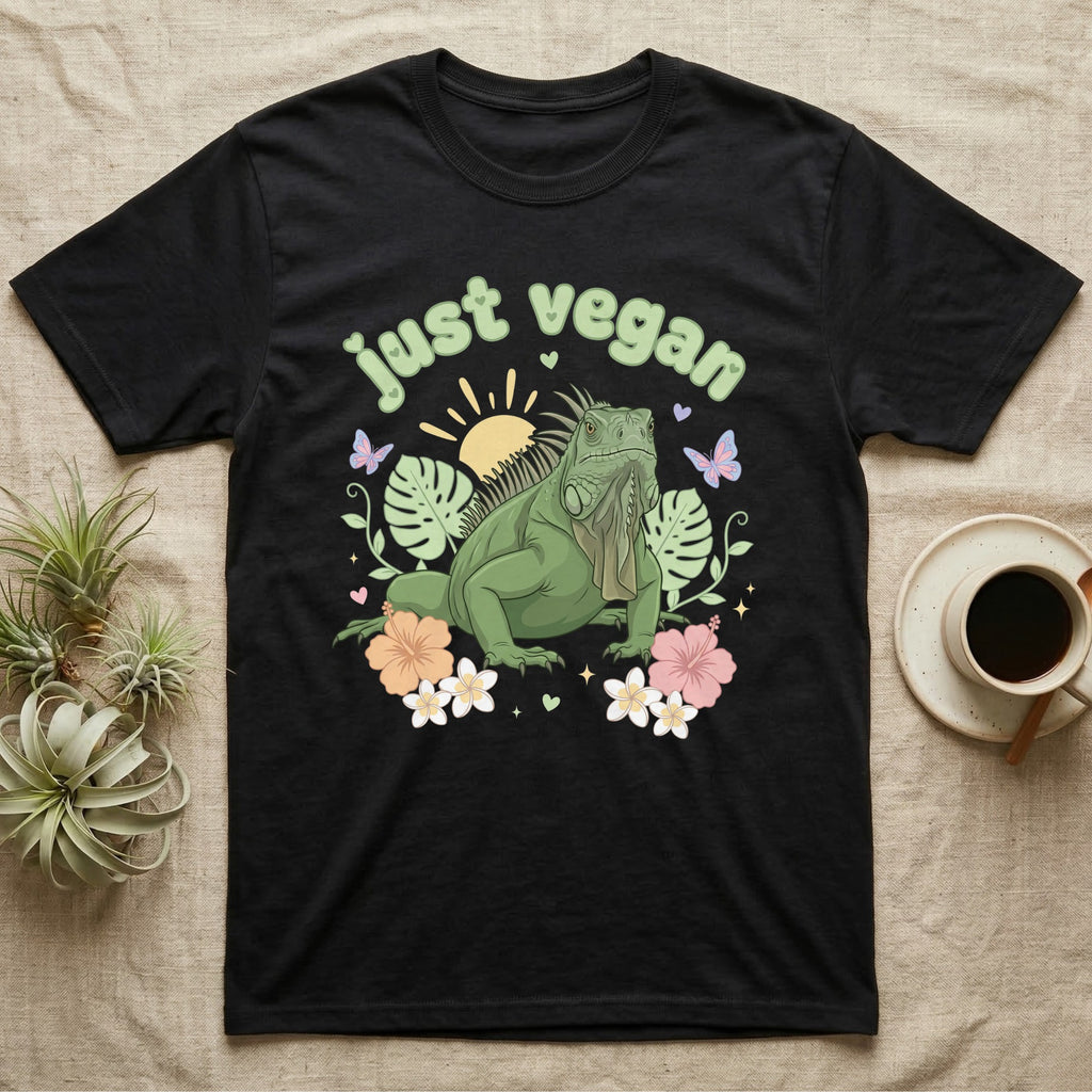 Green Iguana Baby T-Shirt in Black — Green iguana with spiky crest and dewlap among pastel leaves and flowers under puffy green bubble text "just vegan".