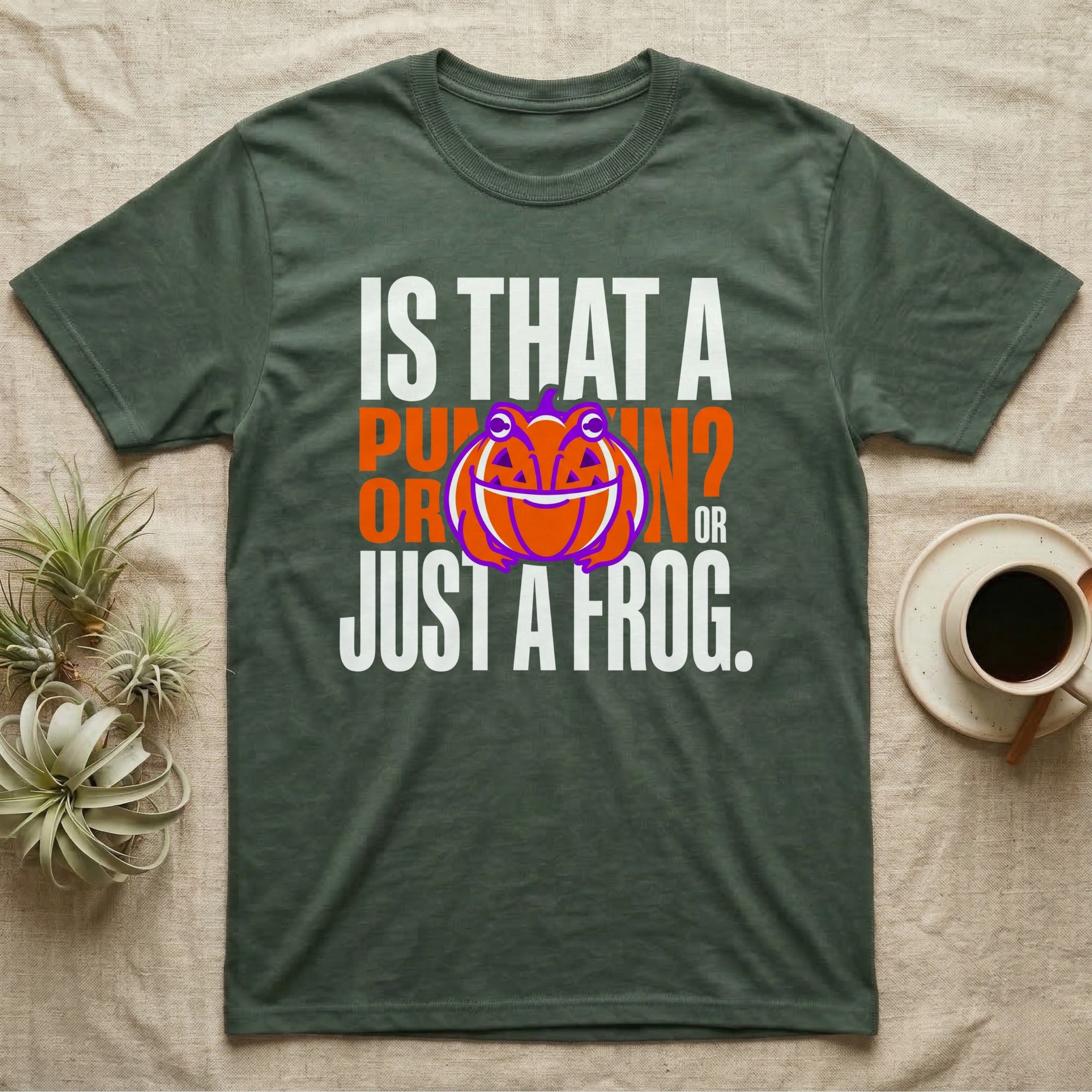 Frog Jack-O'-Lantern Illusion T-Shirt in Military Green — Typographic graphic of an orange frog doubling as a jack-o'-lantern, "Is That a Pumpkin? Or Just a Frog."