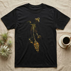 Full-body illustration of an eyelash leaf-tailed gecko mid-climb with a mottled olive-and-gold leaf-shaped tail blending into camouflage texture, no on-shirt text. — shown on a Black tee.