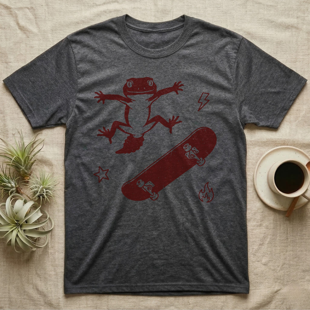 Knob-Tailed Gecko Kickflip T-Shirt in Dark Heather — Distressed one-ink illustration of a knob-tailed gecko airborne mid-kickflip above a tumbling skateboard.