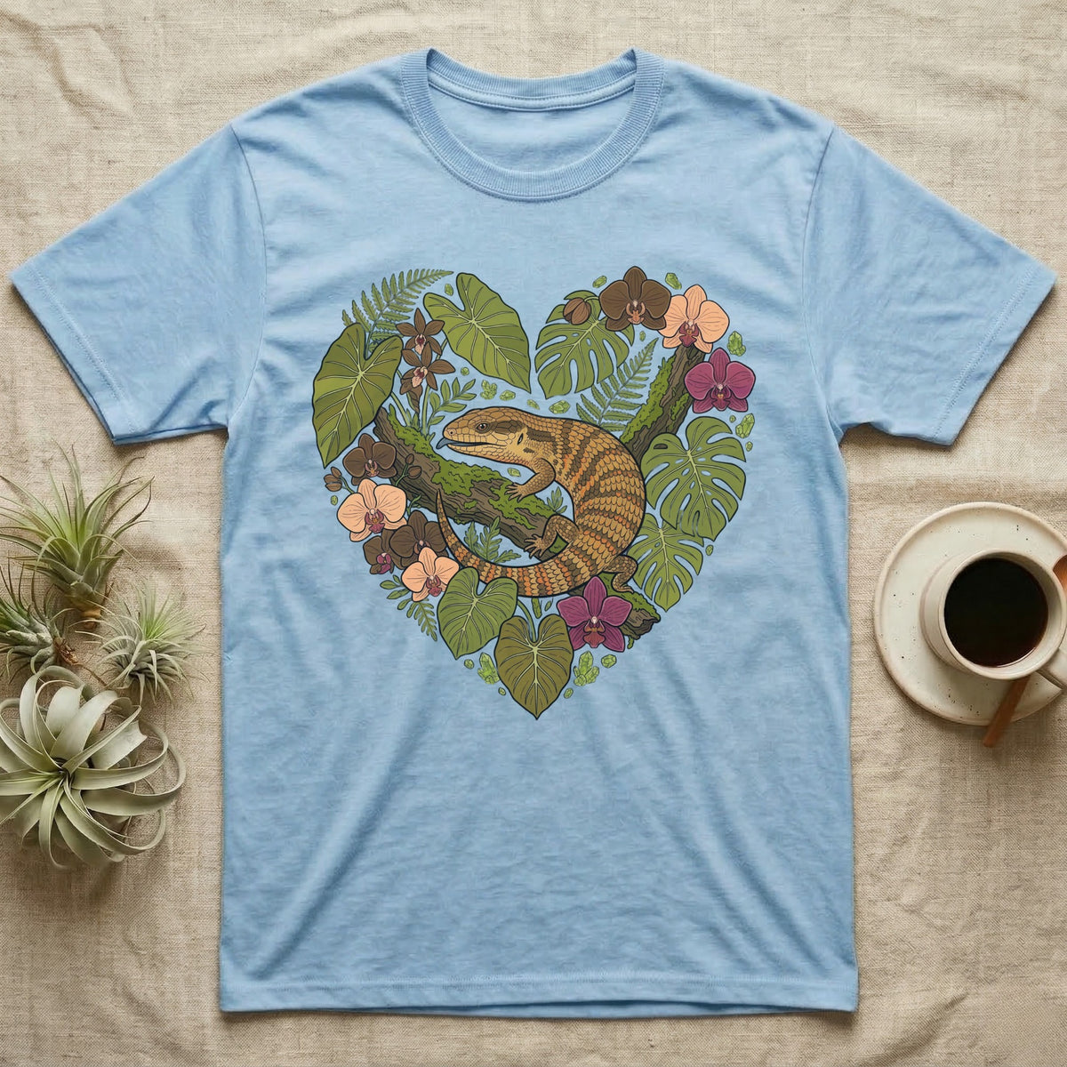 Blue t-shirt with a heart-shaped floral design featuring a lizard.