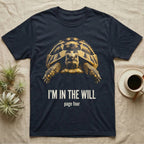 Flat-black mug-shot portrait of a Hermann's tortoise peering from its domed shell, with the printed words I'm In The Will, page four. — shown on a Navy tee.
