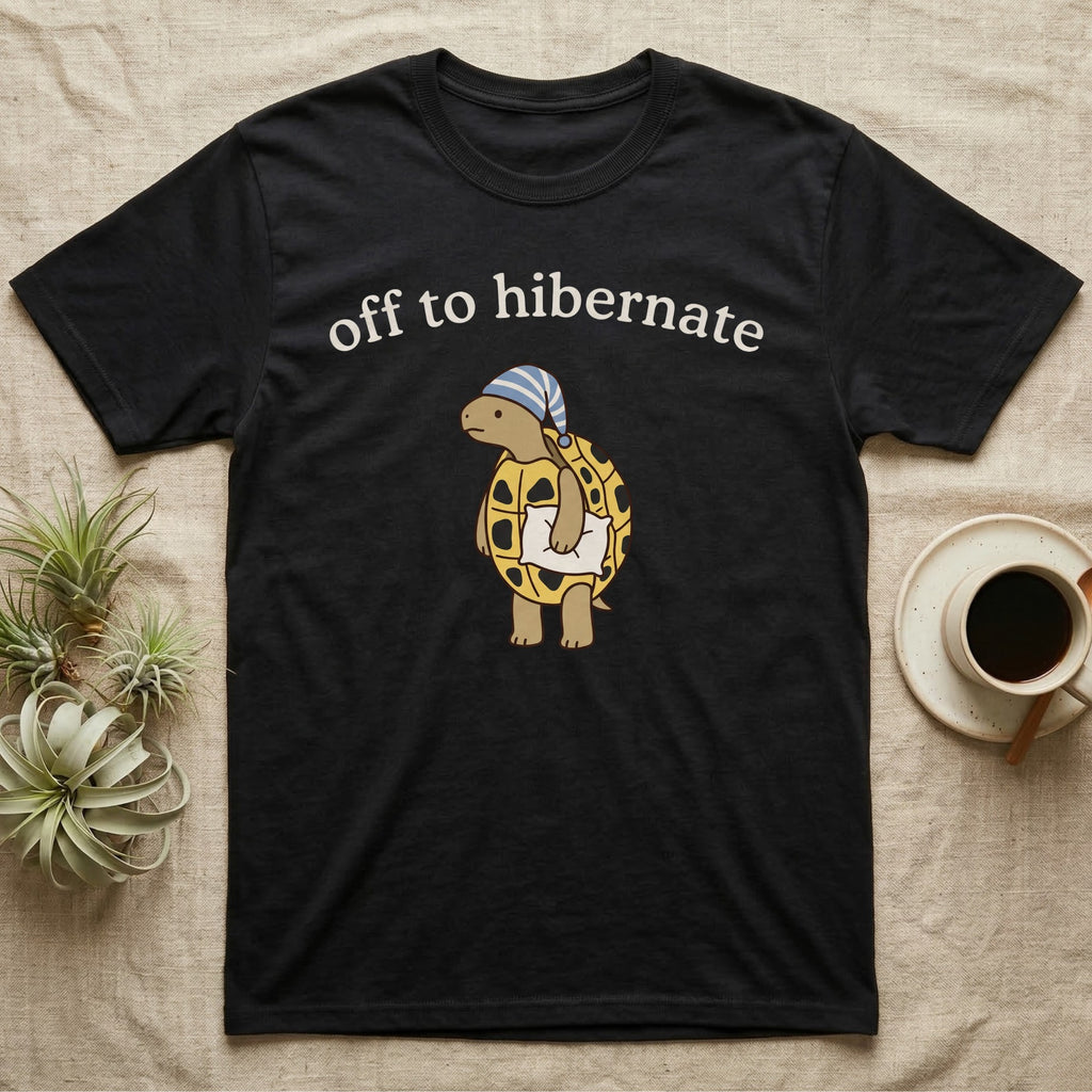Hermann's Tortoise Hibernation T-Shirt in Black — Minimal doodle of a Hermann's tortoise in a striped nightcap holding a pillow under the words off to hibernate