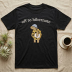 Hermann's Tortoise Hibernation T-Shirt in Black — Minimal doodle of a Hermann's tortoise in a striped nightcap holding a pillow under the words off to hibernate