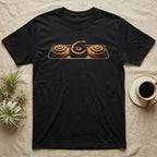 Millipede Cinnamon Roll T-Shirt in Black — A giant African millipede curled like a cinnamon roll on a bakery tray between two iced cinnamon rolls, head raised, on black.