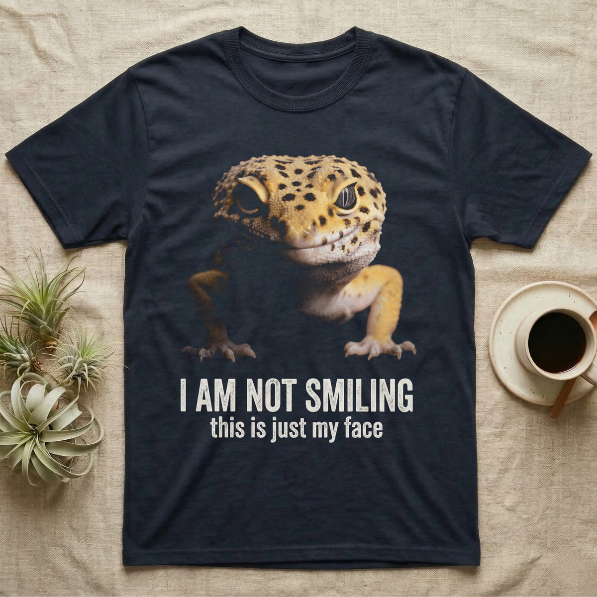 Photographic mugshot of a leopard gecko braced low and staring into the lens above the hook I Am Not Smiling, this is just my face. — shown on a Navy tee.