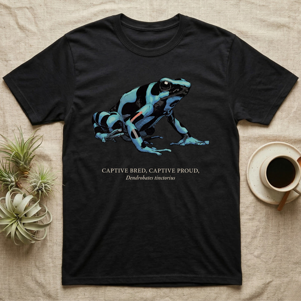Captive Bred Frog T-Shirt in Black — Naturalist-plate illustration of a healthy dyeing dart frog above a serif creed reading Captive Bred Captive Proud.