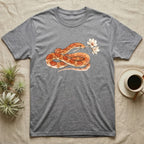 Corn Snake Blossom T-Shirt in Sport Grey — Watercolor illustration of an orange-and-cream corn snake holding a magnolia blossom sprig, on a dark grey t-shirt.
