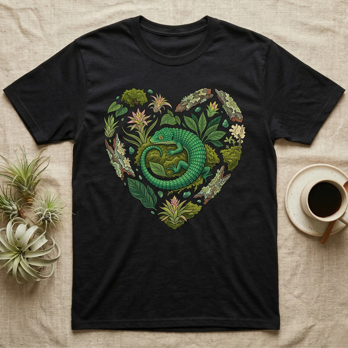 Black t-shirt with green lizard and foliage heart graphic.