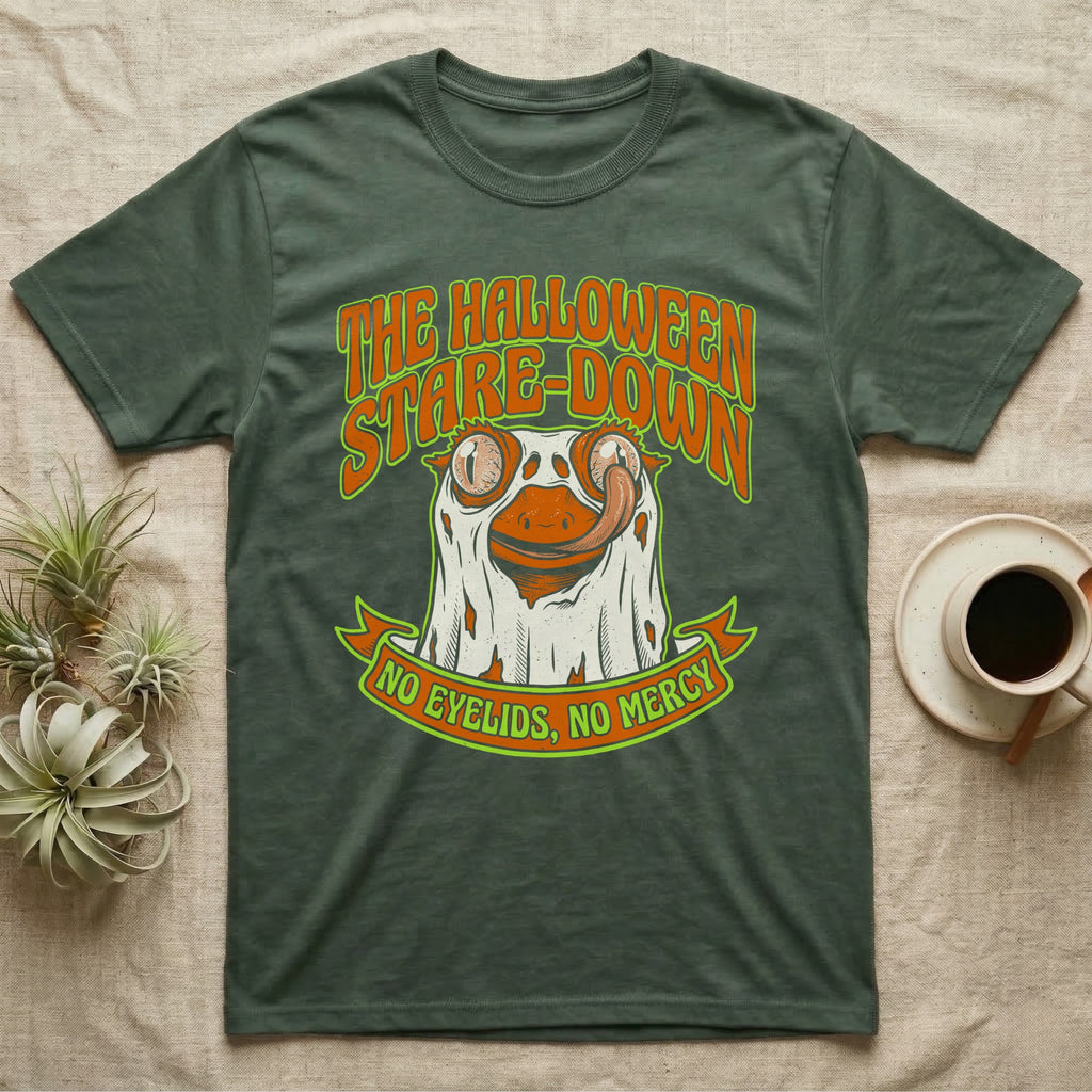 Crested Gecko Halloween Stare-Down T-Shirt in Military Green — Retro-horror crested gecko in a ghost sheet licking its eye, "The Halloween Stare-Down, No Eyelids No Mercy."
