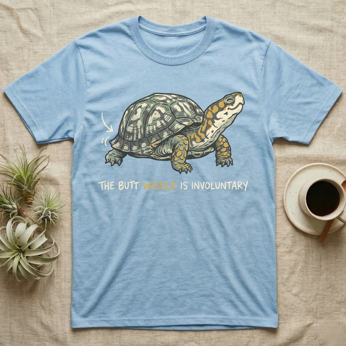 Box Turtle Wiggle T-Shirt in Light Blue — Retro-illustration of a box turtle mid shell-scratch with a hand-drawn arrow at its wiggling rear and a deadpan marker caption.
