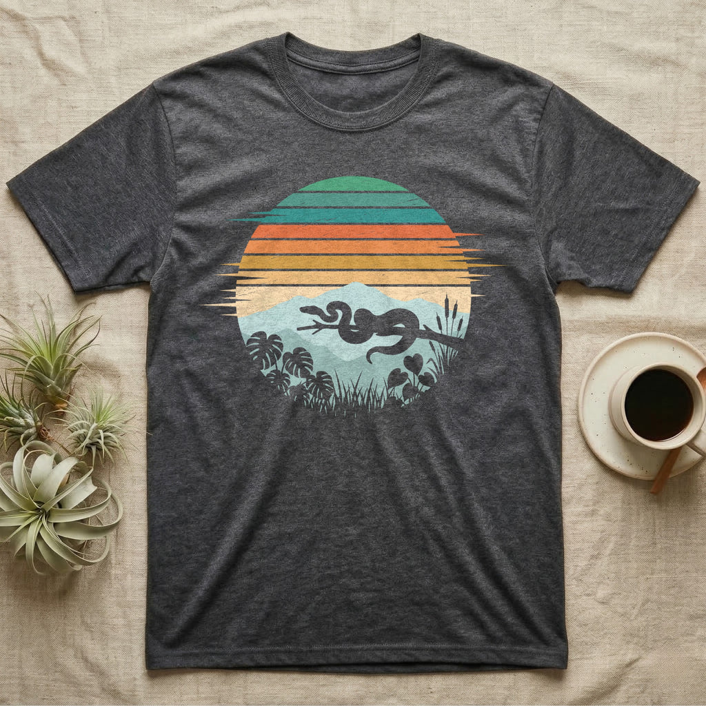 Ball Python Retro Sunset T-Shirt in Dark Heather — Ball python silhouette draped over a branch inside a retro striped sunset disc with monstera leaves on a tee