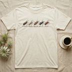 Tarantula Bachelor Parade T-Shirt in Natural — Five tarantulas walking single file in ink and watercolour, small stars scattered in the band above them.