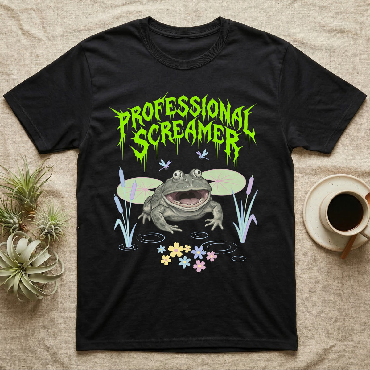 Budgett's Frog Feral T-Shirt in Black — Budgett's frog with wide screaming mouth under jagged acid-green metal text PROFESSIONAL SCREAMER with lily pads