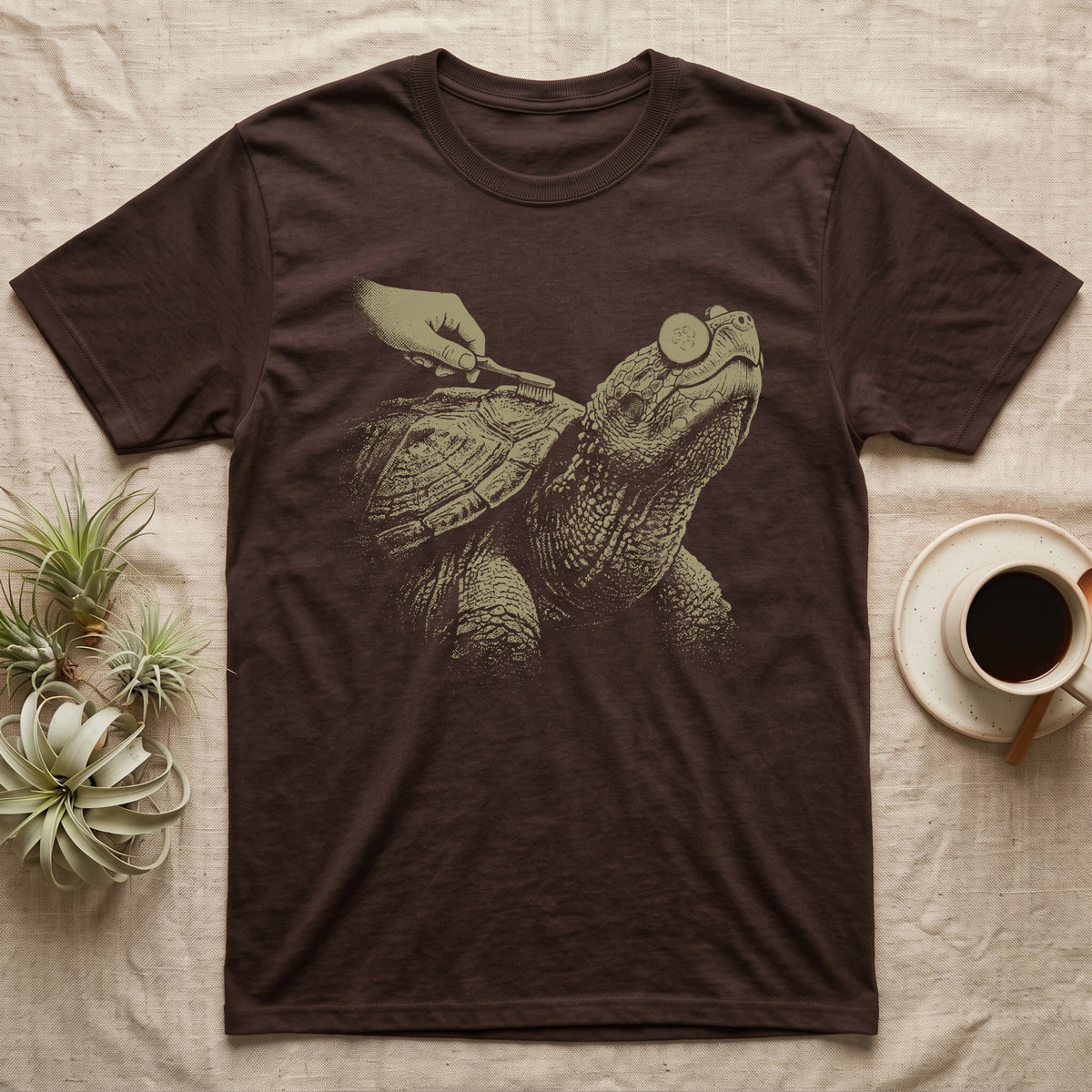 Snapping Turtle Spa T-Shirt in Dark Chocolate — Single-ink snapping turtle with cucumber slices on its eyes, chin up, while a hand scrubs its shell with a toothbrush.