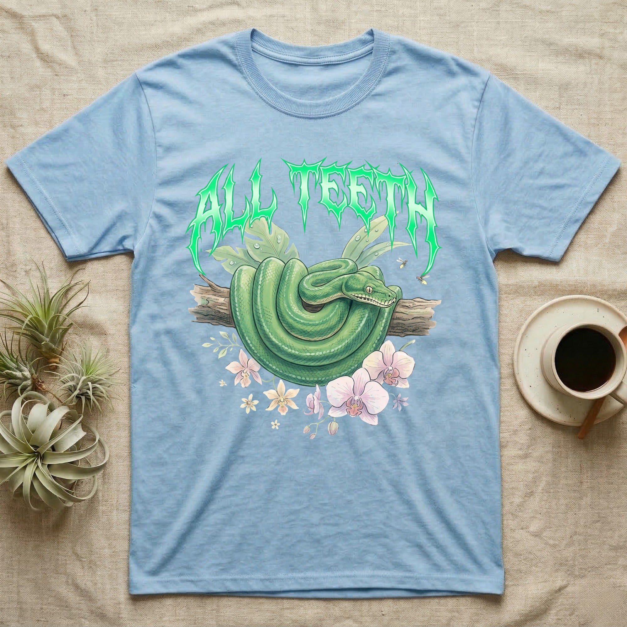 Emerald Tree Boa Feral T-Shirt in Light Blue — Coiled emerald tree boa on a branch below a dripping emerald-green metal "All Teeth" wordmark
