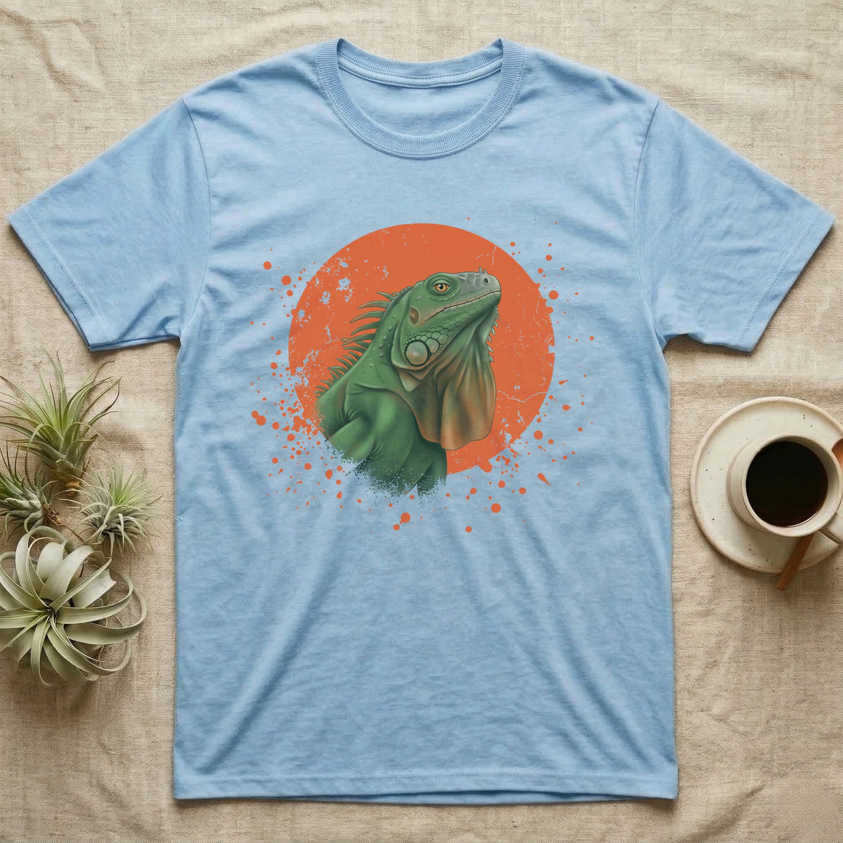 Green Iguana Stink Face T-Shirt in Light Blue — Distressed vintage-style illustration of a green iguana with its dewlap fully dropped and chin lifted, on an orange disc.