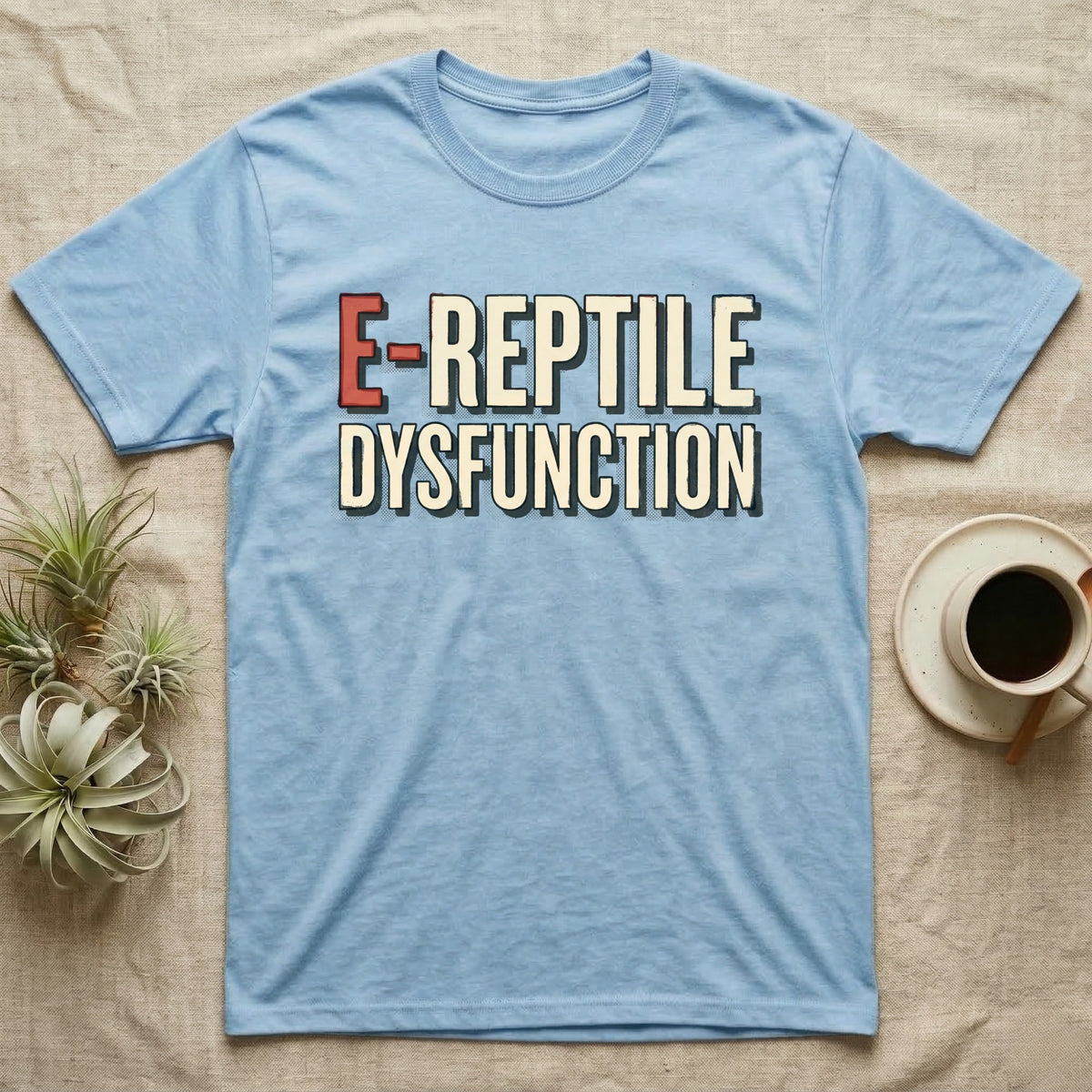 E-Reptile Dysfunction Gecko T-Shirt in Light Blue — Retro-pharmacy typographic wordmark reading "E-Reptile Dysfunction" in distressed cream and tomato-red lettering.