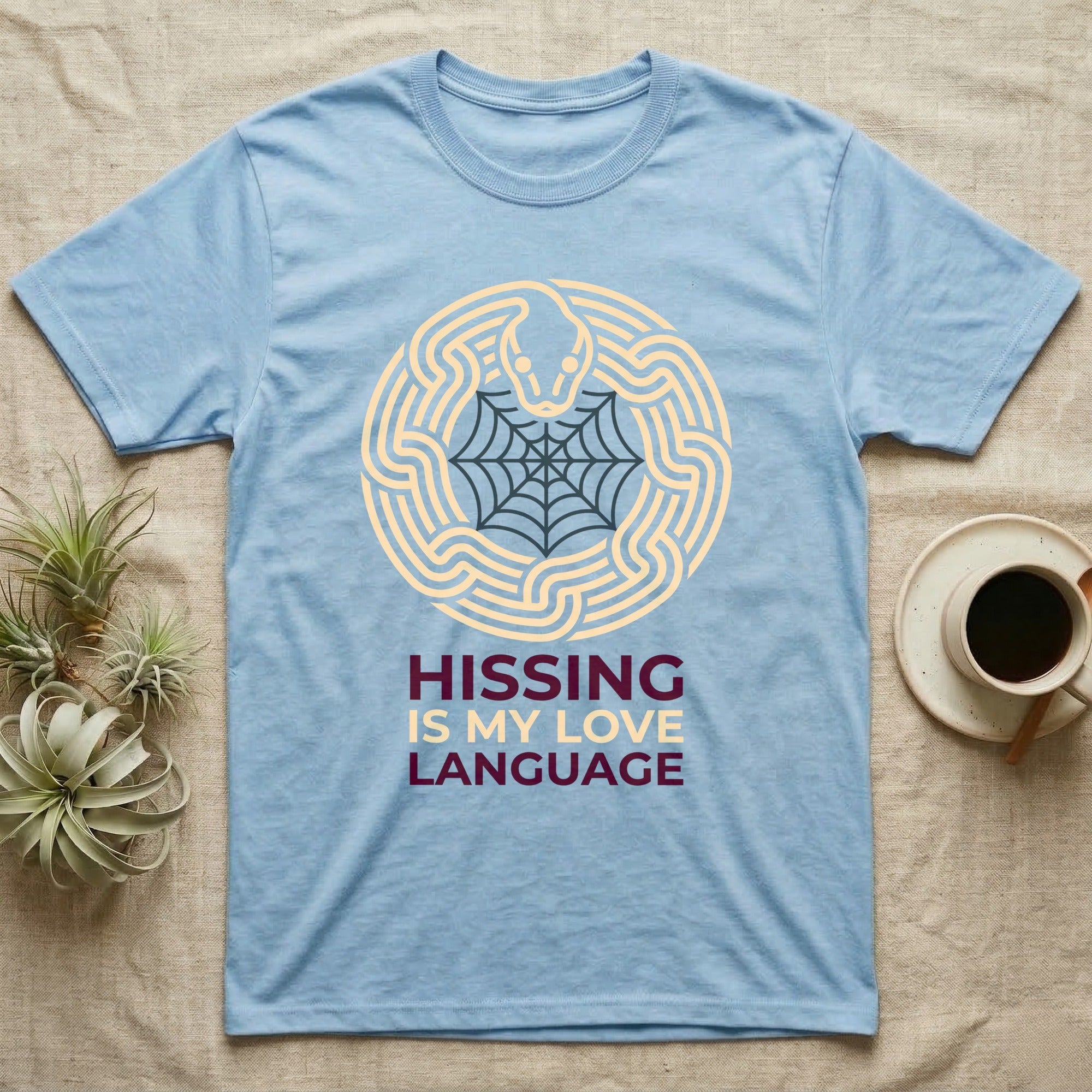 Ball Python Hissing Spiderweb T-Shirt in Light Blue — Minimal continuous-line ball python coiled around a faint spiderweb, "Hissing Is My Love Language."