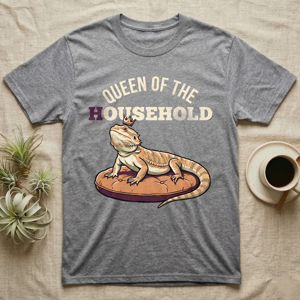 Queen Bearded Dragon T-Shirt in Sport Grey — Bold-vector illustration of a bearded dragon on a throne-cushion with a crown under varsity Queen of the Household lettering.