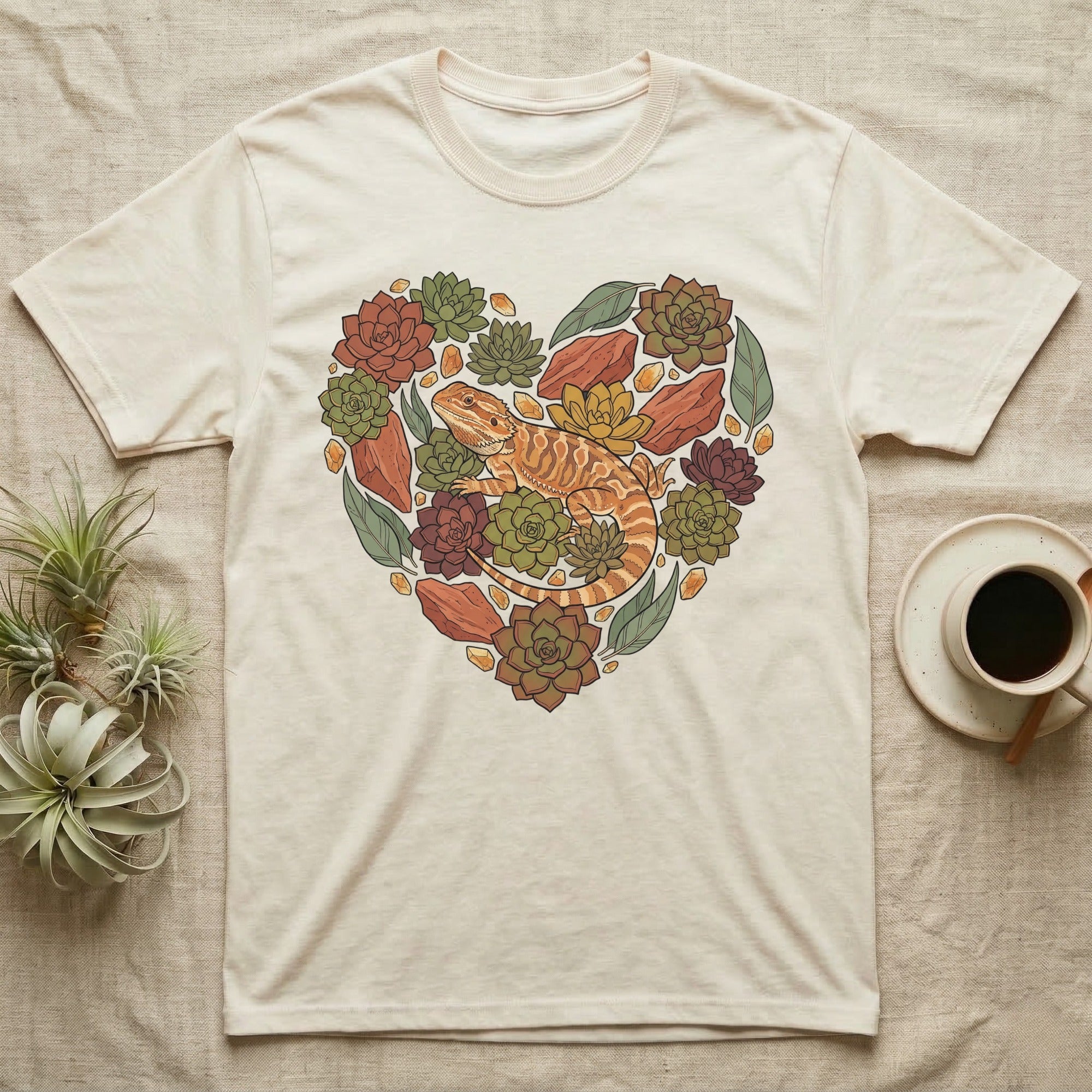 Cream t-shirt with a heart-shaped succulent and lizard design.