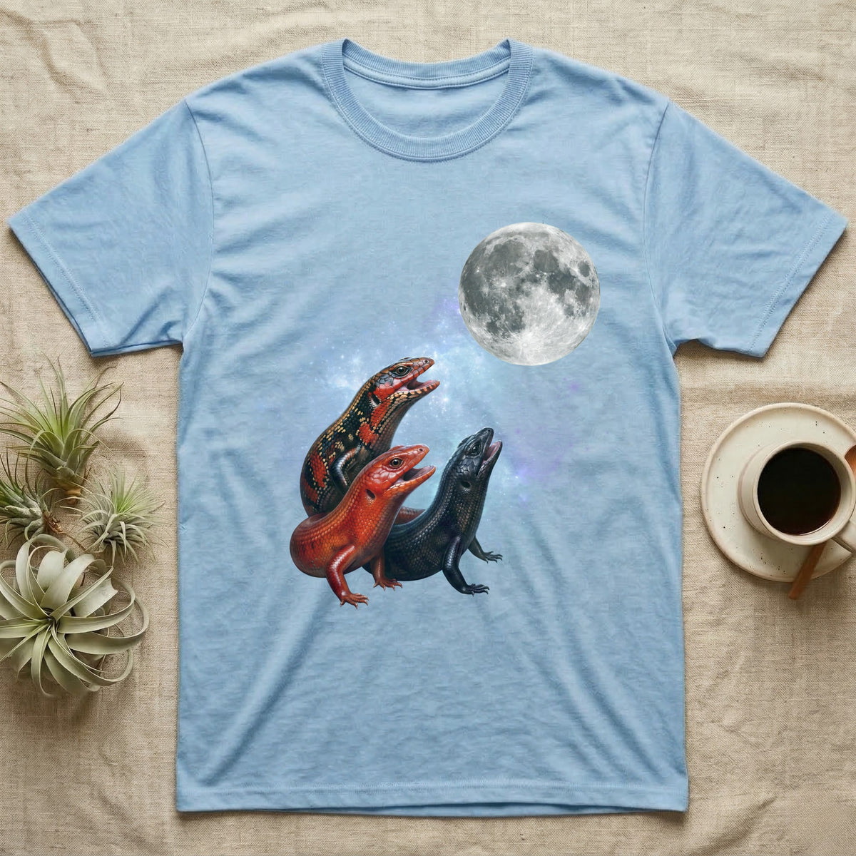 Fire Skink Moon Howl T-Shirt in Light Blue — Three Fire Skink colour morphs howling at a full moon over a nebula on a dark grey t-shirt.