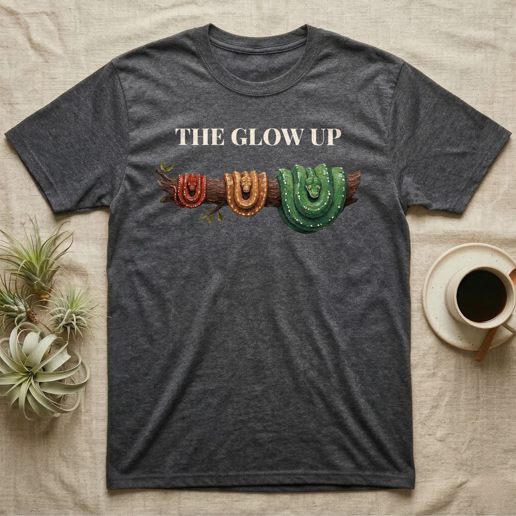 Green Tree Python Glow-Up T-Shirt in Dark Heather — Impasto illustration of a green tree python at three life stages on one branch: red hatchling, orange-brown subadult, green adult.