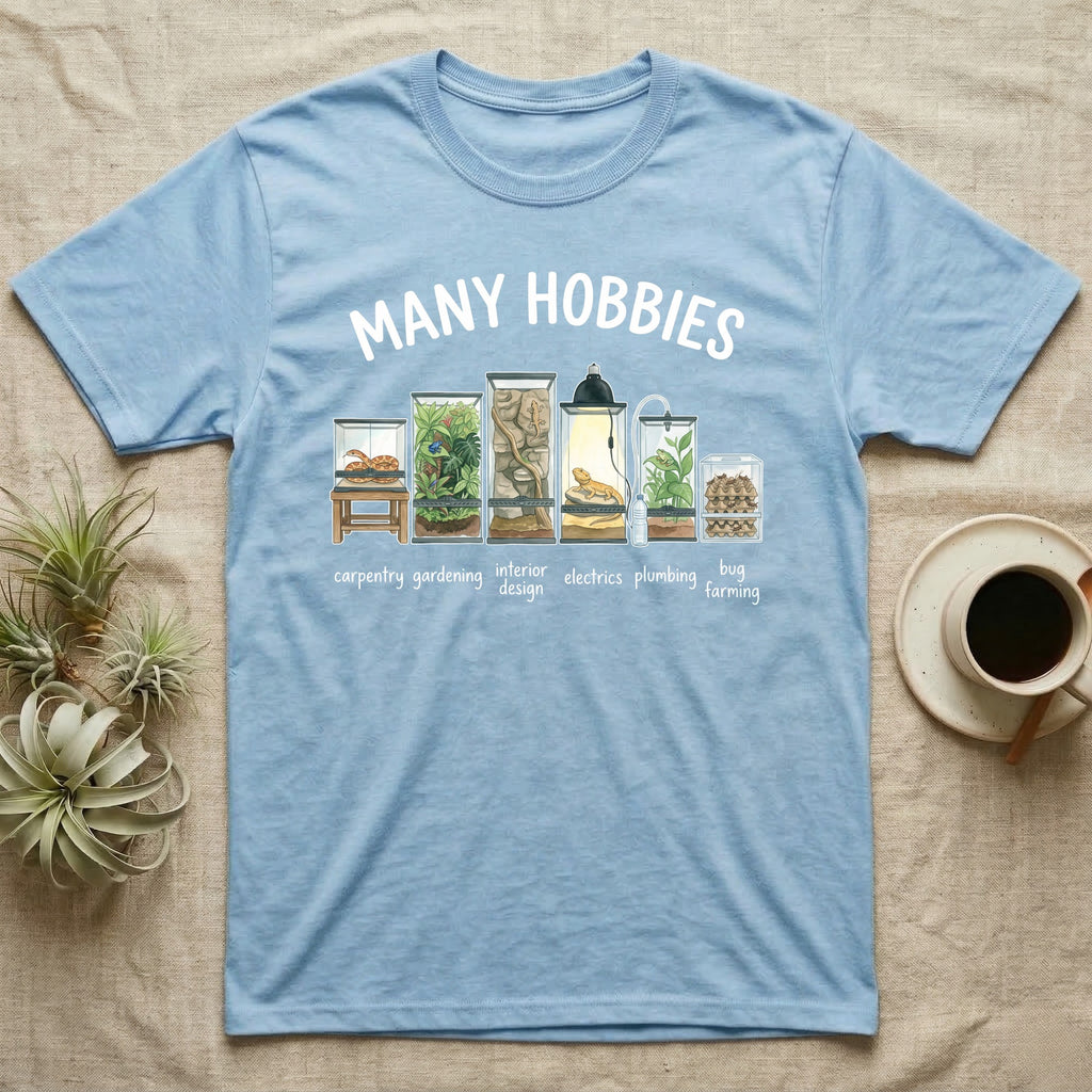 Reptile Terrarium Hobbies T-Shirt in Light Blue — Watercolour row of reptile vivariums with a snake, dart frog, gecko, bearded dragon, tree frog and a cricket bin under MANY HOBBIES, each labelled carpentry to bug farming