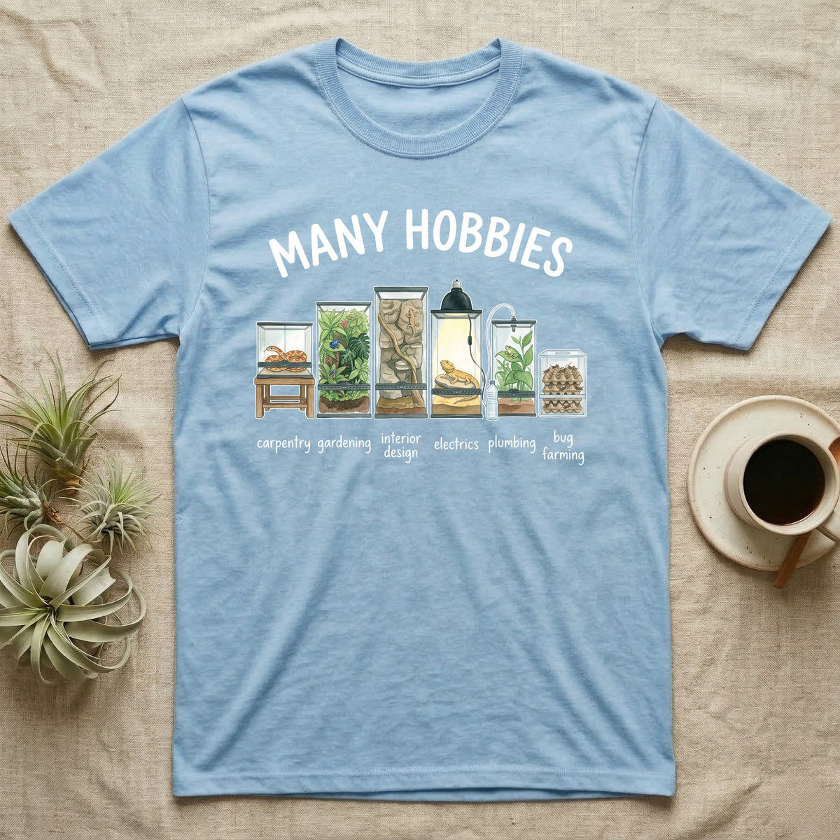 Reptile Terrarium Hobbies T-Shirt in Light Blue — Watercolour row of reptile vivariums with a snake, dart frog, gecko, bearded dragon, tree frog and a cricket bin under MANY HOBBIES, each labelled carpentry to bug farming
