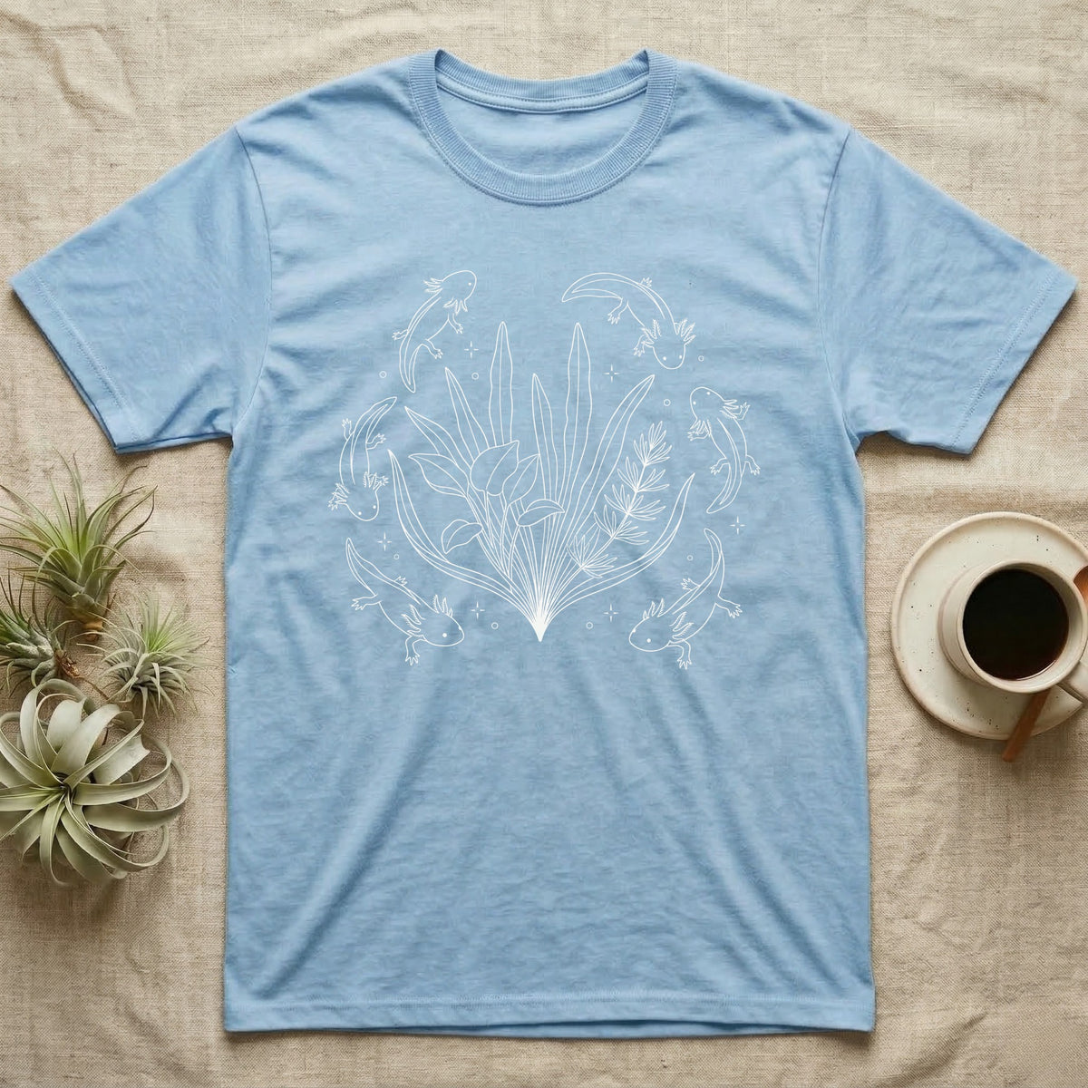 Axolotl Fine Line Botanical T-Shirt in Light Blue — Fine-line white ink illustration of five axolotls drifting around a fanned spray of anubias and java fern.