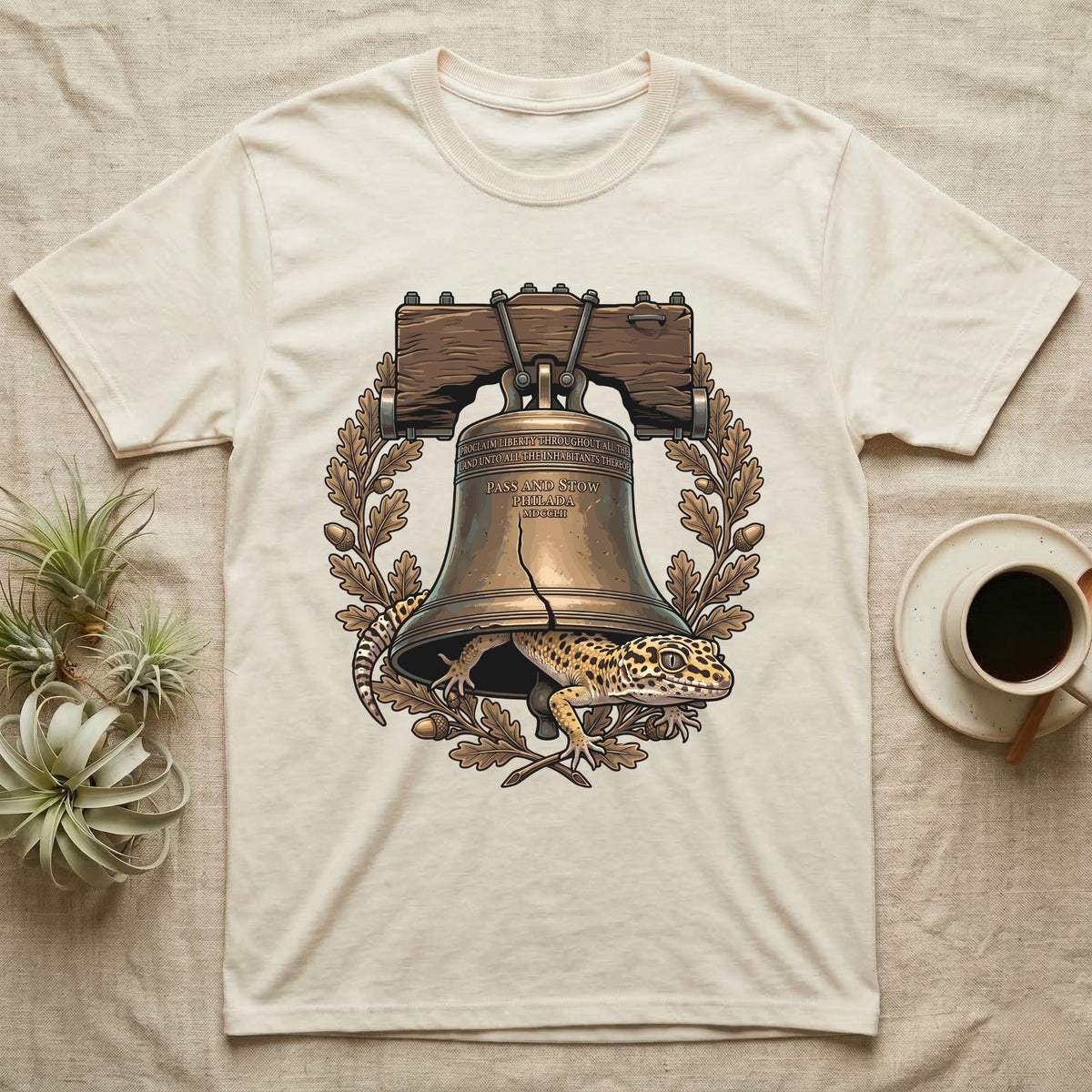 Leopard Gecko Liberty Bell T-Shirt in Natural — Engraved leopard gecko emerging beneath the bronze Liberty Bell inside an oak-leaf and acorn wreath.