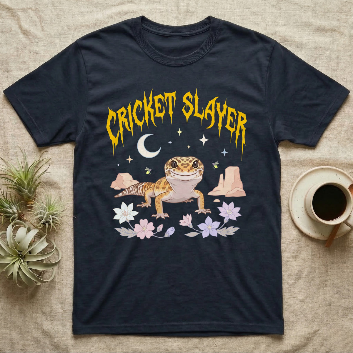 Leopard Gecko Feral T-Shirt in Navy — Smiling leopard gecko in a pastel desert-night scene under a spiky golden metal wordmark reading CRICKET SLAYER.