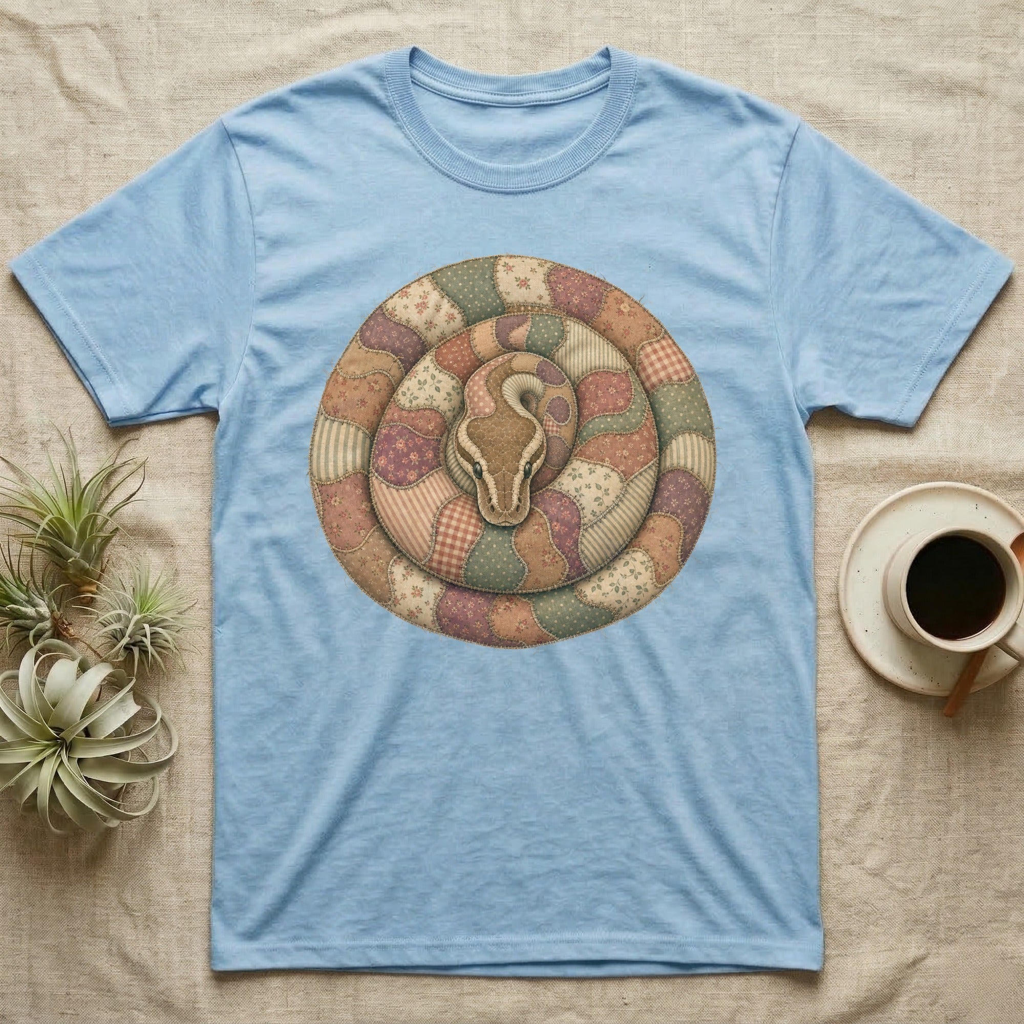 Light blue t-shirt with a coiled snake graphic in a patchwork quilt style.