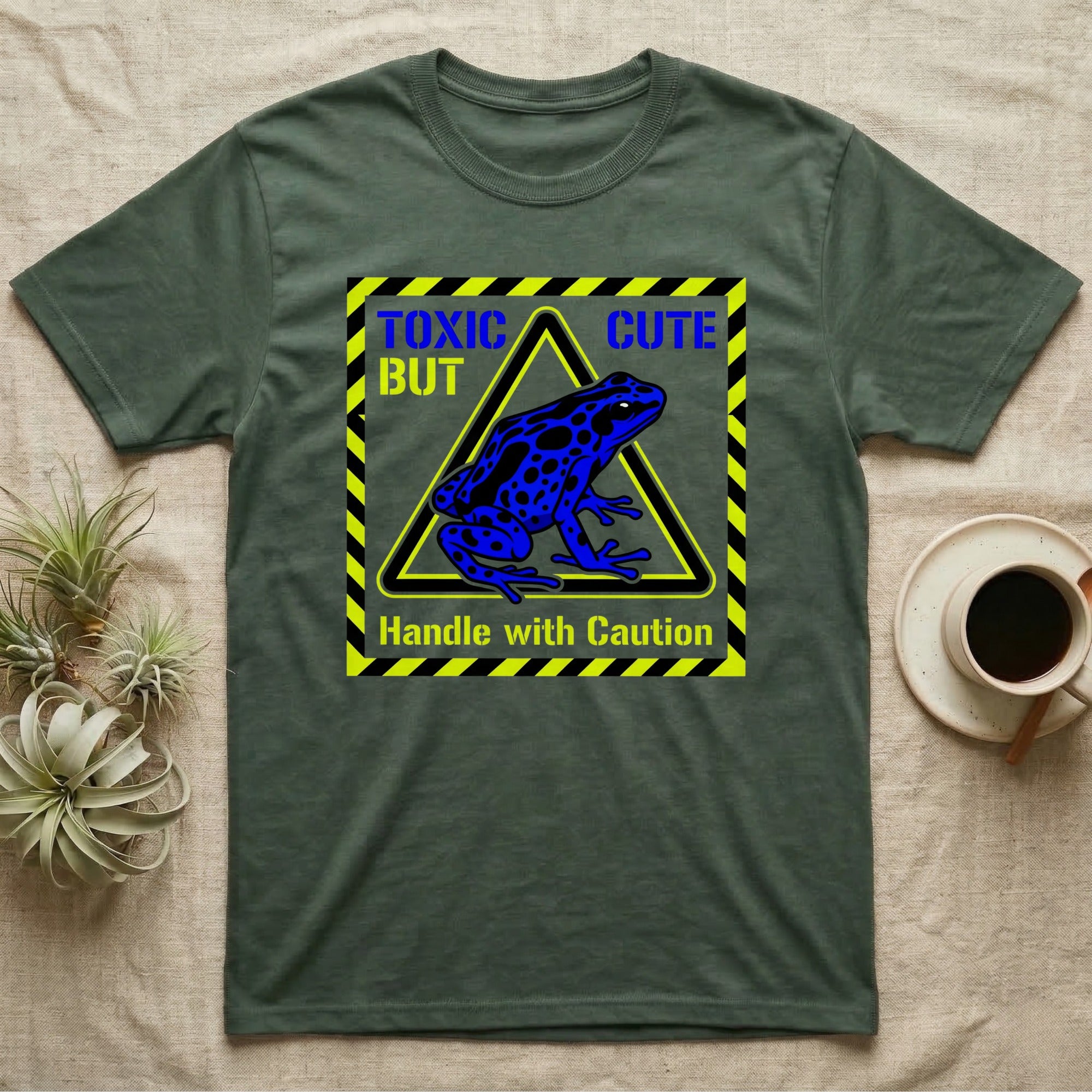 Green t-shirt with blue frog graphic and "TOXIC CUTE Handle with Caution" text.