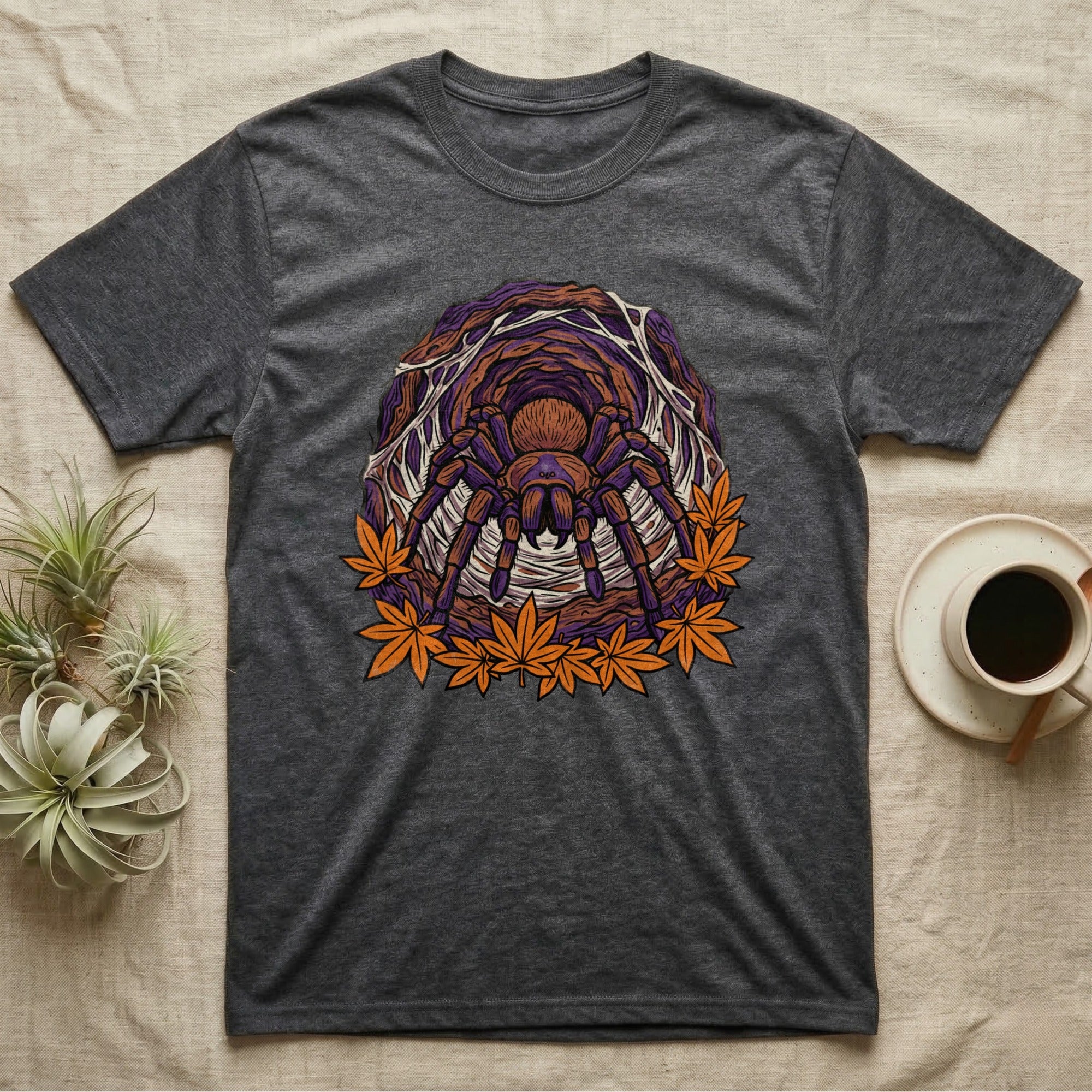 Dark t-shirt with a tarantula and autumn leaves graphic design.