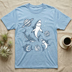 Light blue t-shirt with cartoon sharks wearing astronaut helmets in space.