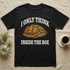 Box Turtle Thinker T-Shirt in Black — Engraved eastern box turtle shut in its shell, one eye peeking out, under I Only Think Inside the Box