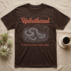 Western Hognose Unbothered T-Shirt in Dark Chocolate — White engraved western hognose snake coiled in loose substrate beside a hide, under the word Unbothered and above it has not eaten since june.