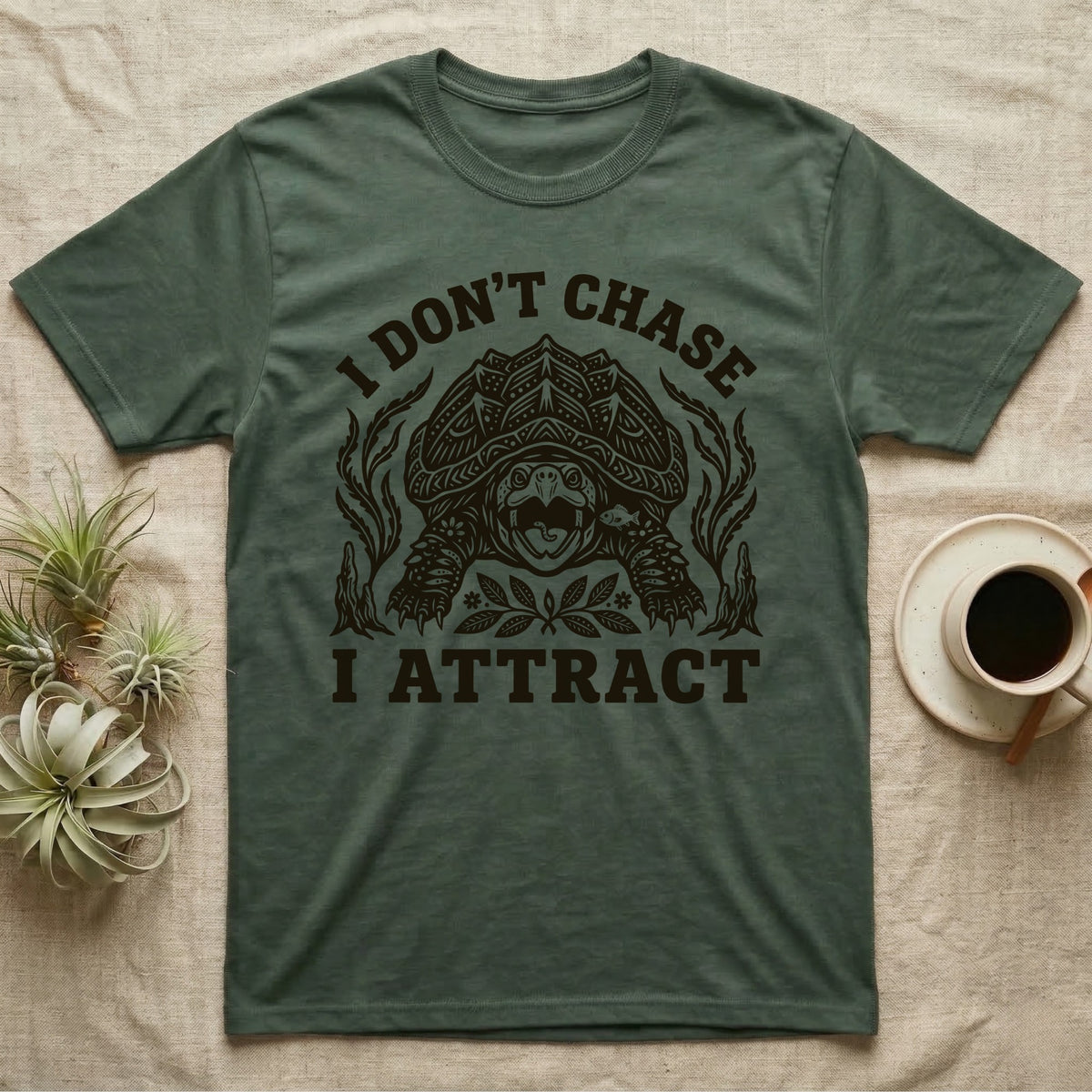 Alligator Snapper Lure T-Shirt in Military Green — Folk-print alligator snapping turtle, jaws open, tongue lure out, a fish swimming in, text I Don't Chase I Attract