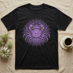 Vampire Crab Folk Medallion T-Shirt in Black — Violet woodblock vampire crab seen face-on, its raised claws cut into a contained folk sunburst medallion.