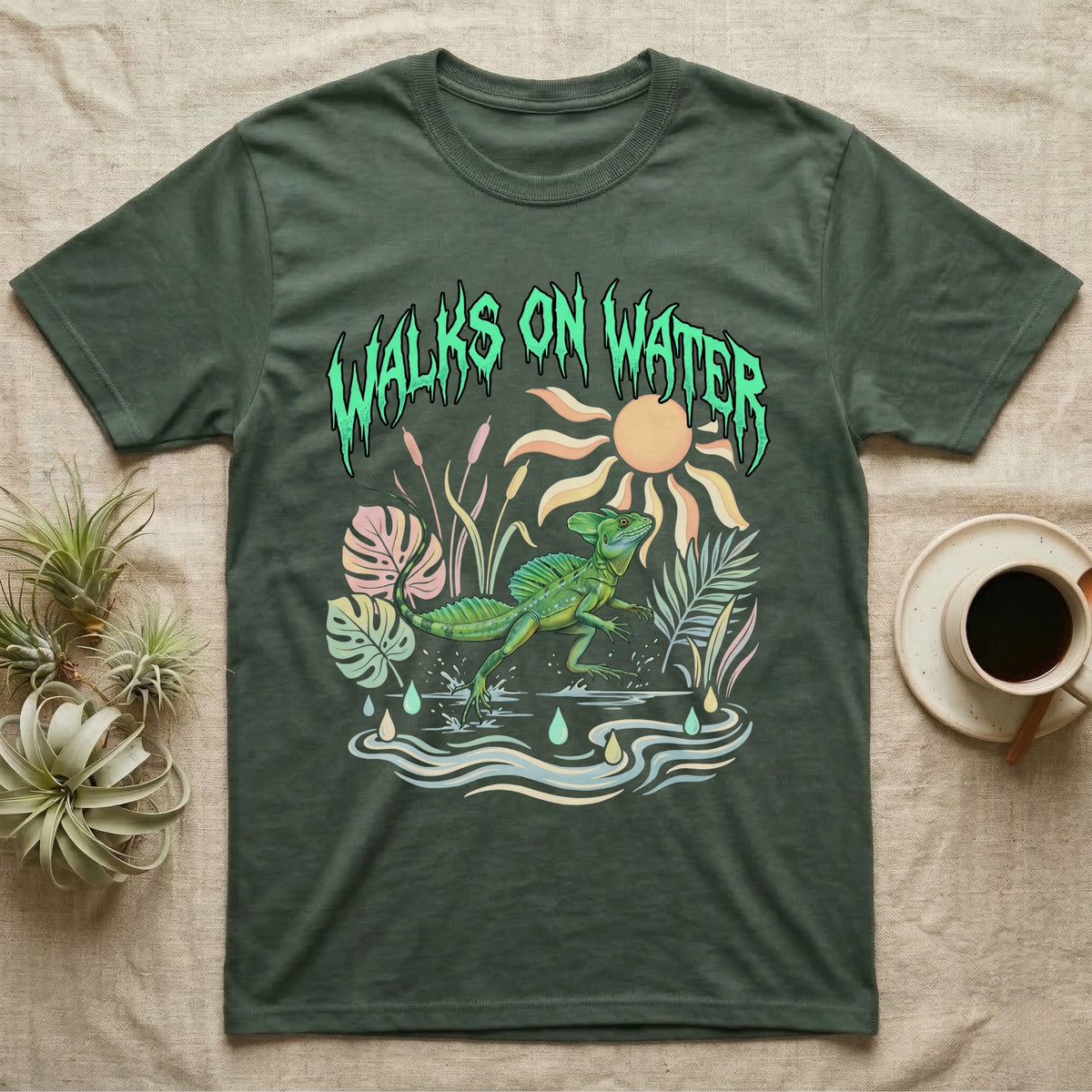 Green Basilisk Feral T-Shirt in Military Green — Green plumed basilisk sprinting across water below a dripping aqua-green metal "Walks On Water" wordmark