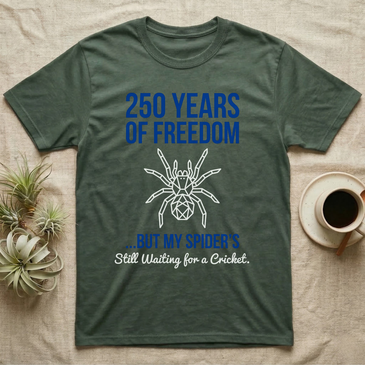 Tarantula Waiting For Cricket Tee in Military Green — Minimalist geometric tee with a low-poly white tarantula and blue text reading 250 Years Of Freedom but my spider's still waiting for a cricket.