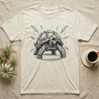 Sulcata Tortoise Charcoal Grit T-Shirt in Natural — Sulcata tortoise drawn head-on in scribbled charcoal grit, legs braced wide, zigzag bolts thrown out around it.